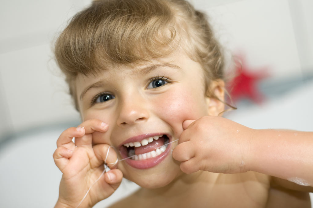 child flossing teeth properly